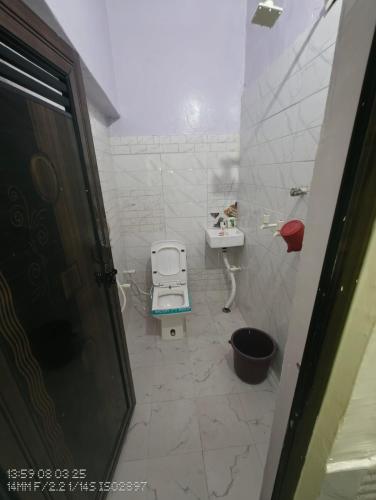 a small bathroom with a toilet and a sink at Aastha Krishna Homestay in Mathura