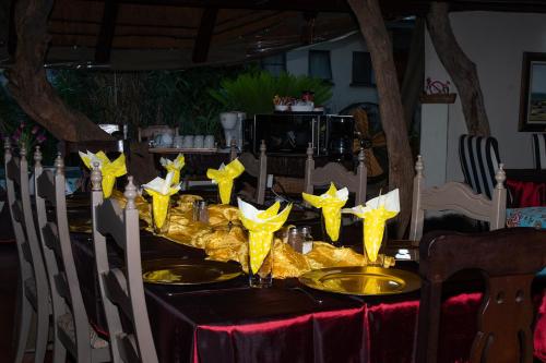 a table with yellow napkins and yellow stars on it at Dei Gratia Guest House in Musina