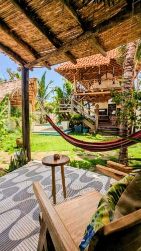a patio with a hammock and a table and a bench at Nuevo NAYAL in Las Peñitas