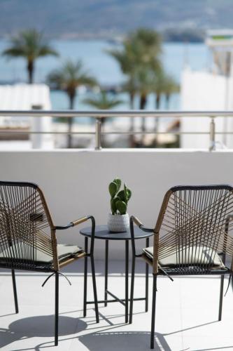 two chairs and a table with a potted plant on a balcony at Casa di Cornaro in Sitia