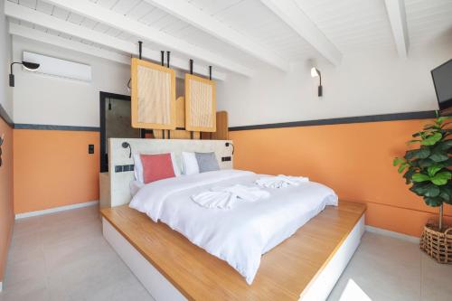 a bedroom with a large white bed with orange walls at Casa di Cornaro in Sitia