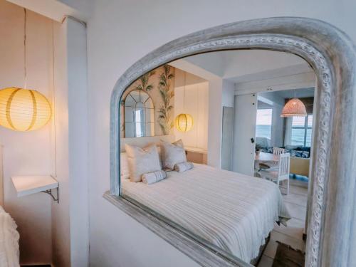 a bedroom with a large mirror above a bed at OCEAN SHOREBREAK - Umdloti resort - Back up Water in Umdloti