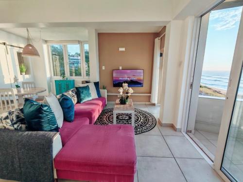 a living room with a couch and a tv at OCEAN SHOREBREAK - Umdloti resort - Back up Water in Umdloti