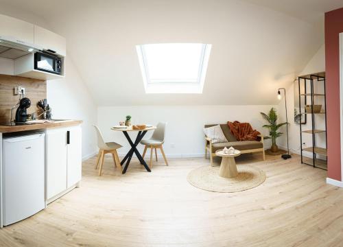 Il comprend une cuisine et un salon avec une table. dans l'établissement Studio Paprika 2pers Wi-Fi, à Cambrai