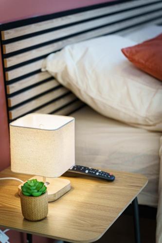 une table avec un ordinateur au-dessus d'un lit dans l'établissement Studio Paprika 2pers Wi-Fi, à Cambrai