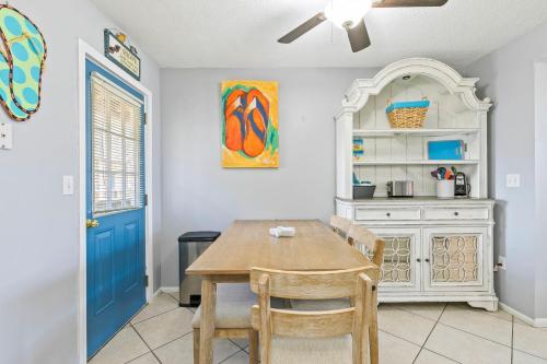 a dining room with a table and a blue door at 2BR Condo w Pool Beach Access and Walk to Hangout in Gulf Shores