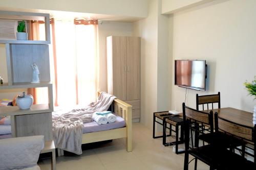 a living room with a table and a dining room at ComfyCabin 3 AVIDA TOWERS RIALA IT PARK CEBU CITY in Cebu City