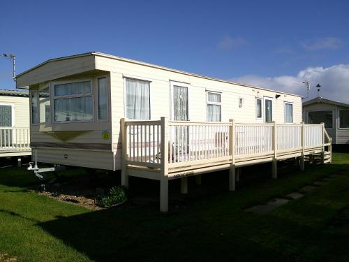 a white mobile home with a porch and a deck at Sealands Canberra 6 Berth Central Heated Access to the beach in Ingoldmells