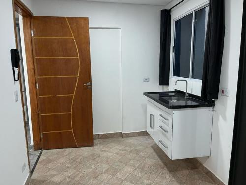 a bathroom with a sink and a window and a door at Condomínio Residencial Vitória 3 in Sao Paulo