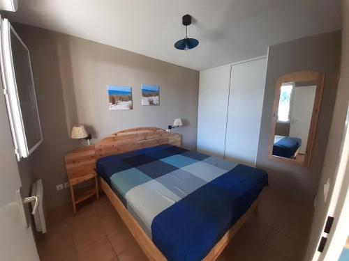 - une chambre avec un lit bleu dans l'établissement Appt 40m2 Résidence 3*** 10mn plages, à Soulac-sur-Mer