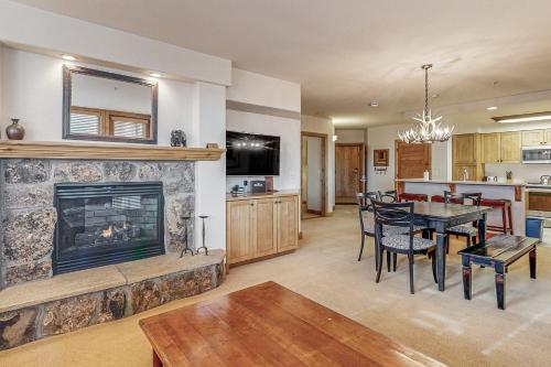 a living room with a fireplace and a dining room at Torian Plum Creekside 415 in Steamboat Springs