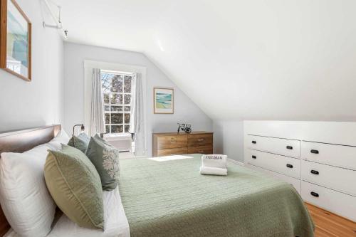 a bedroom with a large bed with a green blanket at Steps to Dining Less than 1 mile to Bayside Beaches in Dennis