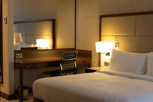 a hotel room with a bed and a desk and a chair at DoubleTree by Hilton Hotel & Conference Centre Warsaw in Warsaw
