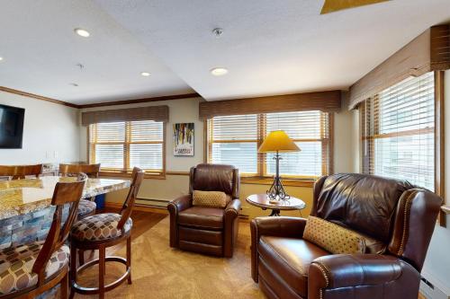 sala de estar con sillas de cuero y mesa en Torian Plum Plaza 508, en Steamboat Springs