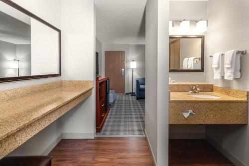 a hotel bathroom with two sinks and a mirror at AmericInn by Wyndham Valley City Conference Center in Valley City