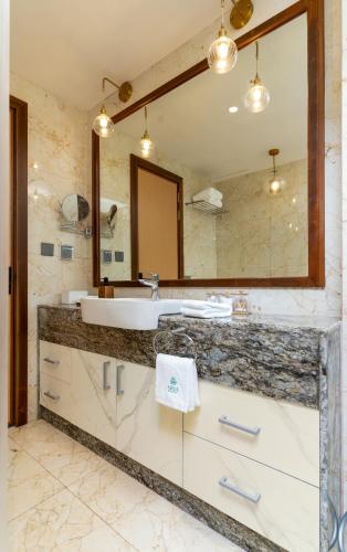 a bathroom with a sink and a large mirror at ARIA Beach, Ukulhas in Ukulhas