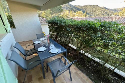 une table et des chaises assises sur une terrasse dans l'établissement T2 with Sea View - Domaine de la Pinède - Heated Pool, au Lavandou