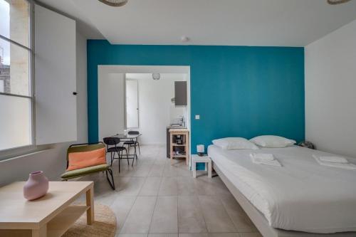 une chambre avec un grand lit et un mur bleu dans l'établissement Beau studio confortable Bordeaux, à Bordeaux