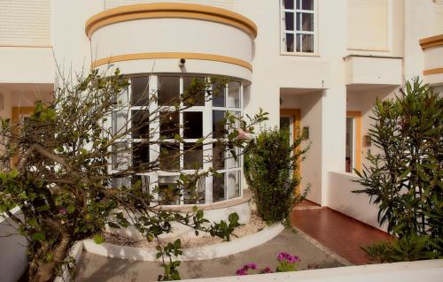 un edificio con una ventana redonda y algunas plantas en Balili Beach House, en Ferrel