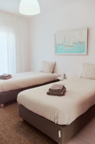 two beds sitting next to each other in a room at Balili Beach House in Ferrel