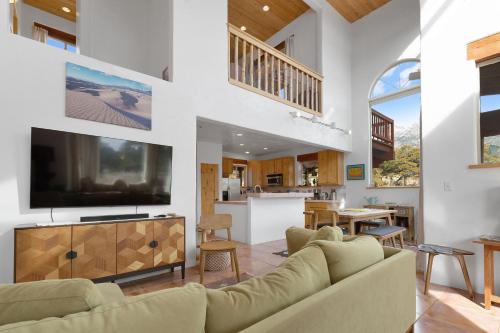 a living room with a couch and a tv at Crestone Adobe Vista Manor in Crestone