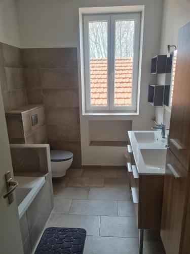 une salle de bain avec toilettes, lavabo et fenêtre dans l'établissement Les Beaux Chais, à Beaucaire