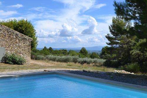 a swimming pool in front of a stone house at Large Provençal Bastide - With Private Pool in Cucuron