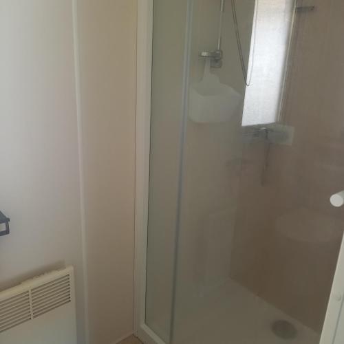 une douche avec une porte vitrée dans une salle de bain dans l'établissement Mobil-home Saint Jean de mont, à Saint-Jean-de-Monts