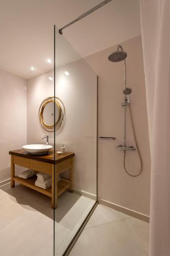 a bathroom with a shower with a sink and a mirror at La Maltese Residence in Imerovigli