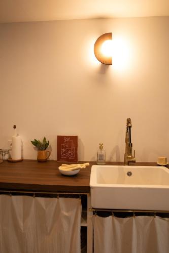 La salle de bains est pourvue d'un lavabo et d'une lumière sur le mur. dans l'établissement Grand duplex plein coeur Vauban, à Marseille