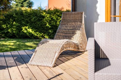 a wicker chair sitting on a wooden deck at Ferienwohnung Eichenhof in Blankensee