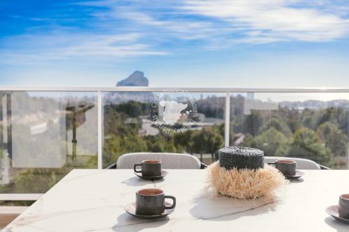 - une table avec deux tasses à café et un chapeau dans l'établissement CostaBlancaDreams Real Ifach Axan in Calpe, à Calp