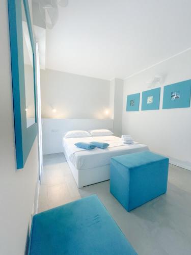 a white room with a bed and a blue stool at Antica Osteria sant Andrea in Misinto