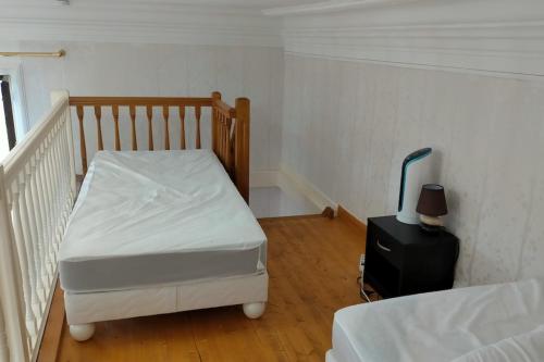 Cette petite chambre comprend un lit et une valise. dans l'établissement Studio le 121 - Palace Le Bernascon, à Aix-les-Bains