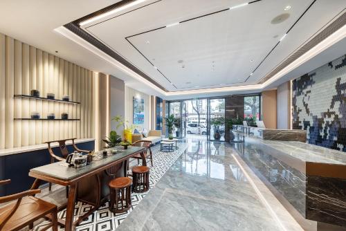 a lobby with a long table and chairs at Lijiang OKDAY HOTEL in Lijiang