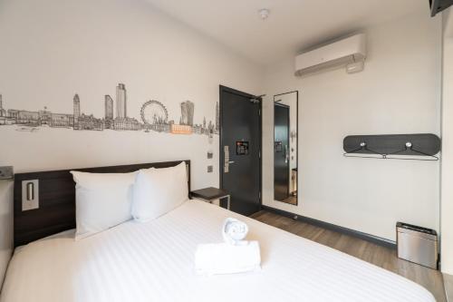 a bedroom with a white bed and a mirror at easyHotel Victoria in London