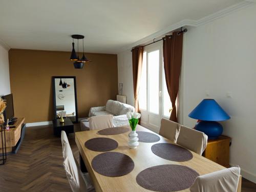 un salon avec une table et un canapé dans l'établissement Bel appartement proche gare et centre ville, au Mans