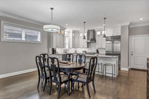 a dining room and kitchen with a table and chairs at Elegant Condo-Steps from Wrigley Field, 32 Nights condo in Chicago