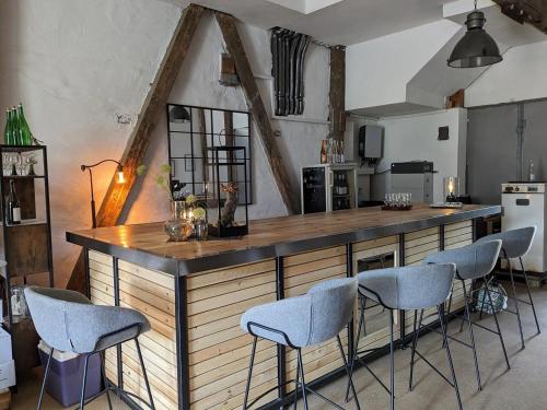a kitchen with a bar with four stools at Gästehaus Weingut Mangel in Endingen