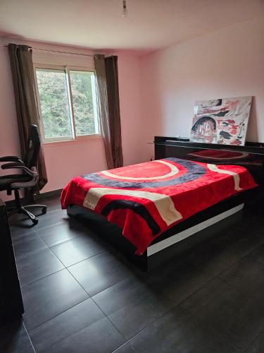 une chambre avec un lit avec une couverture rouge dessus dans l'établissement Maison de village, à Pietracorbara