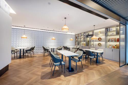 a dining room with tables and chairs at Lijiang OKDAY HOTEL in Lijiang