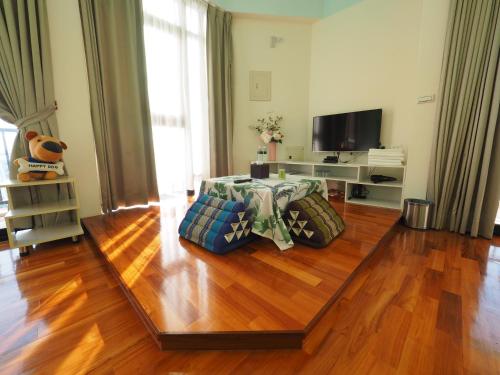 a living room with a wooden floor and a television at 198紅帽民宿l市區l2025冷氣全面換新 in Magong