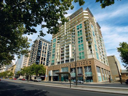 a tall building on a city street with buildings at Oaks Adelaide Embassy Suites in Adelaide