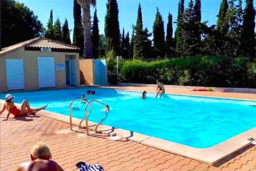 un groupe de personnes dans une piscine dans l'établissement Logement avec jardinet dans résidence avec piscine, à Sanary-sur-Mer