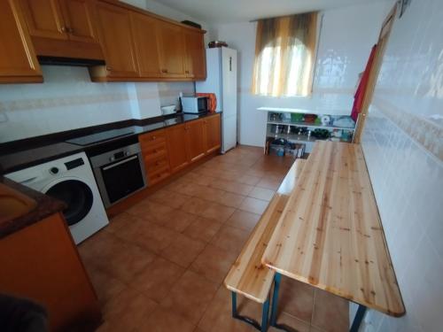 a kitchen with a wooden table and a stove at Valencia, villa, piscina privada, junto A-7 cerca de playas, aeropuerto, Cheste in Torrent