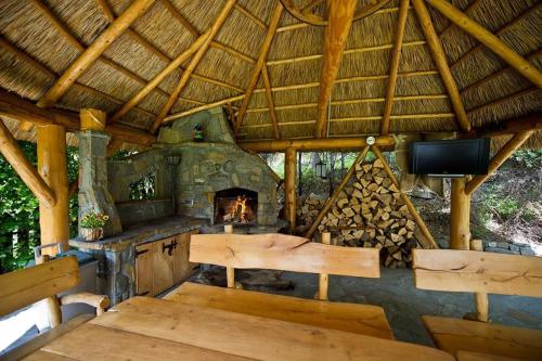 a large outdoor kitchen with a fireplace and a television at Pensjonat Absynt in Nowy Targ