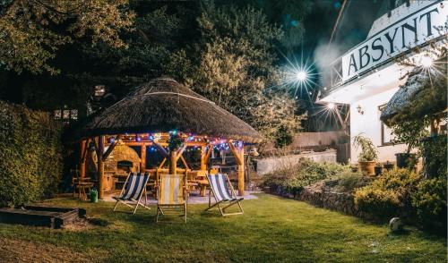 a gazebo with chairs in the yard at night at Pensjonat Absynt in Nowy Targ