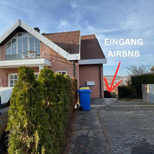 a house with a blue trash can in front of it at Apartment in Rimpar in Rimpar