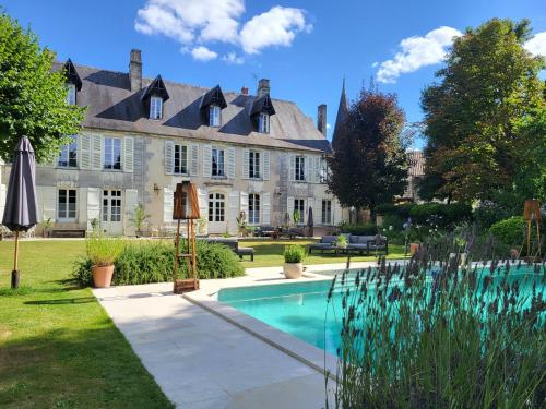 une grande maison avec une piscine dans la cour dans l'établissement Logis des Tourelles Appartement, à Cognac