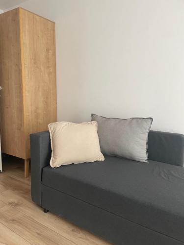 a gray couch with a white pillow in a room at Pensjonat Absynt in Nowy Targ